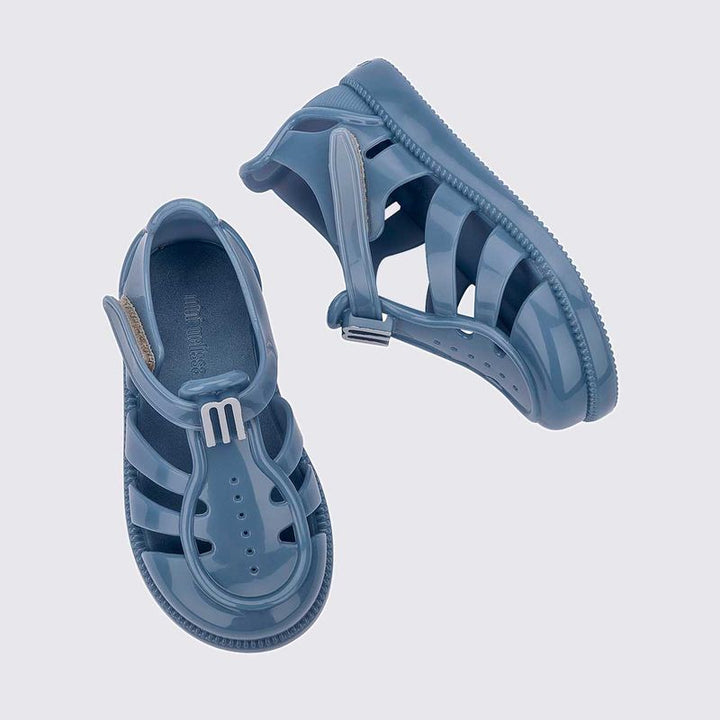 Sandália infantil Mini Melissa Hip Daydream Baby na cor azul, com tiras vazadas, fechamento em velcro e detalhe com o 'M' da marca. Produzida em Melflex, é leve, confortável e segura, ideal para os primeiros passos com estilo e praticidade.

Palavra-chave principal: Mini Melissa Hip Daydream Baby
Palavras-chave relacionadas: sandália azul baby, Melflex, sandália infantil, fechamento em velcro, primeiros passos, calçado confortável, estilo baby.