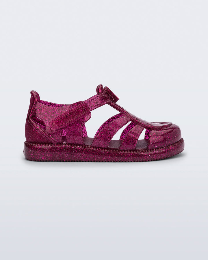Sandália infantil Mini Melissa Hip Daydream Baby na cor bordô com acabamento glitter. Modelo com tiras vazadas, fechamento em velcro e detalhe frontal com o 'M' da marca. Produzida em Melflex, é leve, confortável e ideal para os primeiros passos com segurança e muito brilho.

Palavra-chave principal: Mini Melissa Hip Daydream Baby
Palavras-chave relacionadas: sandália baby bordô, glitter, Melflex, calçado infantil, fechamento em velcro, primeiros passos, conforto infantil, brilho