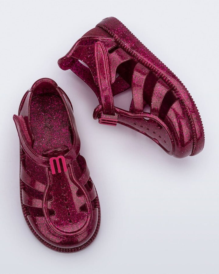Sandália infantil Mini Melissa Hip Daydream Baby na cor bordô com acabamento glitter. Modelo com tiras vazadas, fechamento em velcro e detalhe frontal com o 'M' da marca. Produzida em Melflex, é leve, confortável e ideal para os primeiros passos com segurança e muito brilho.

Palavra-chave principal: Mini Melissa Hip Daydream Baby
Palavras-chave relacionadas: sandália baby bordô, glitter, Melflex, calçado infantil, fechamento em velcro, primeiros passos, conforto infantil, brilho