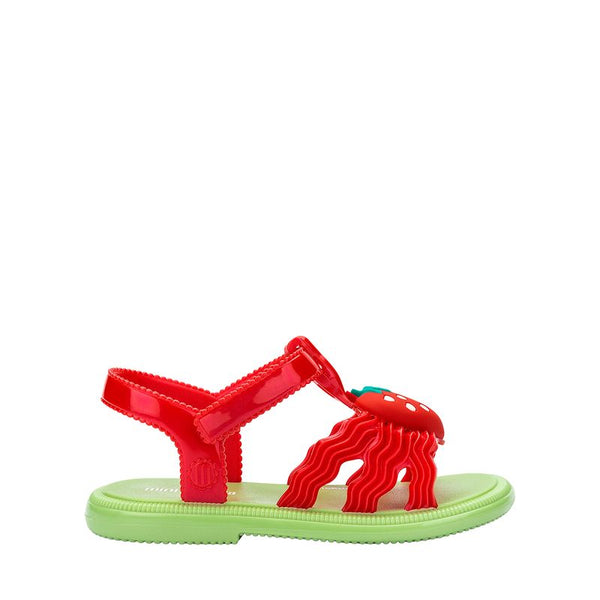 Sandália infantil Mini Melissa Hip Sandal Baby nas cores verde e vermelho, com tiras largas e fechamento em velcro. Confeccionada em Melflex, é leve, confortável e segura, ideal para acompanhar os primeiros passos com estilo divertido e prático