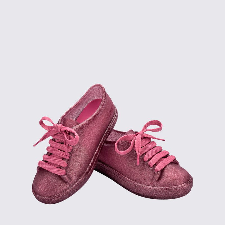 Tênis infantil Mini Melissa Hip Sneaker na cor rosa com glitter, feito em Melflex, com design moderno e solado robusto. Modelo confortável e estiloso, ideal para o dia a dia das crianças com praticidade e muito brilho