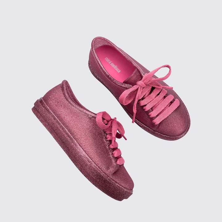 Tênis infantil Mini Melissa Hip Sneaker na cor rosa com glitter, feito em Melflex, com design moderno e solado robusto. Modelo confortável e estiloso, ideal para o dia a dia das crianças com praticidade e muito brilho
