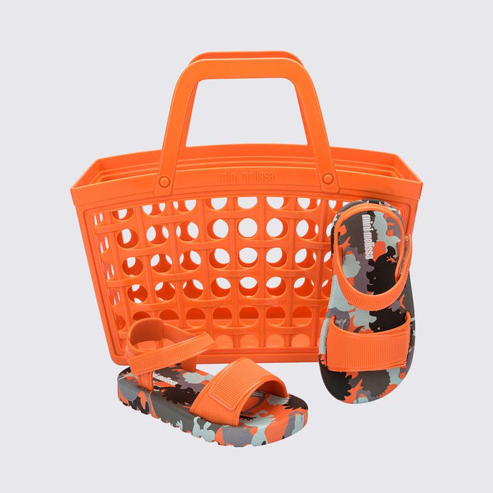 Sandália infantil Mini Melissa Imagine Baby nas cores laranja e verde, com acabamento estampado vibrante e divertido. Feita em material Melflex, macia, leve e confortável, possui fechamento ajustável que garante segurança para os primeiros passos. O conjunto acompanha uma charmosa bolsa de mão combinando nas mesmas cores, com capacidade de 5 litros, perfeita para levar itens essenciais com praticidade e muito estilo no dia a dia.