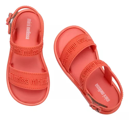 Sandália infantil Mini Melissa Mar Sandal M.Lover Baby na cor laranja, com tiras em formato de corações coloridos. Produzida em Melflex, é leve, confortável e possui fechamento ajustável, ideal para os primeiros passos com segurança e estilo