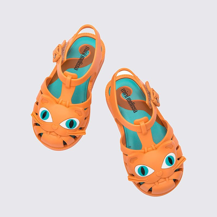 Sandália infantil Mini Melissa Possession Cat Baby nas cores laranja e azul, com aplicação de carinha de gatinho no cabedal. Confeccionada em Melflex, possui tiras vazadas, fecho com fivela e solado confortável. Um calçado divertido e estiloso para o dia a dia das crianças.

Palavra-chave principal: Mini Melissa Possession Cat Baby
Palavras-chave relacionadas: sandália infantil laranja azul, Melflex, sandália de gatinho, fecho com fivela, calçado baby confortável, estilo lúdico.