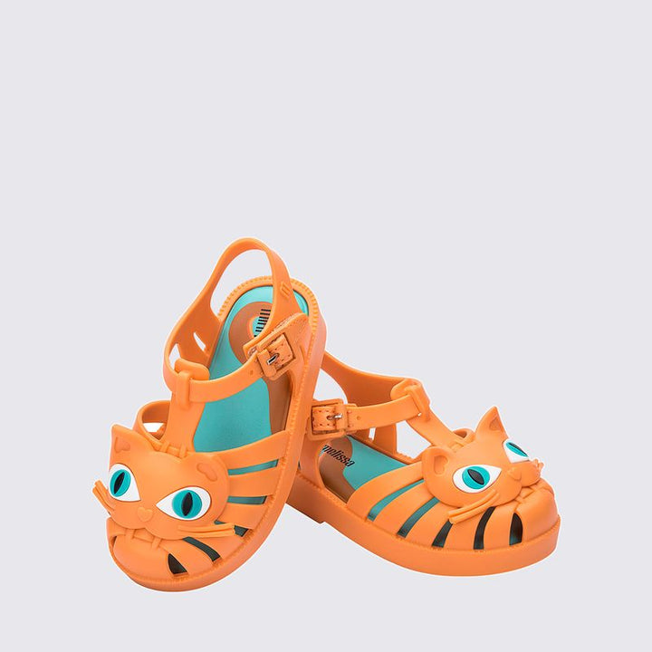 Sandália infantil Mini Melissa Possession Cat Baby nas cores laranja e azul, com aplicação de carinha de gatinho no cabedal. Confeccionada em Melflex, possui tiras vazadas, fecho com fivela e solado confortável. Um calçado divertido e estiloso para o dia a dia das crianças.

Palavra-chave principal: Mini Melissa Possession Cat Baby
Palavras-chave relacionadas: sandália infantil laranja azul, Melflex, sandália de gatinho, fecho com fivela, calçado baby confortável, estilo lúdico.