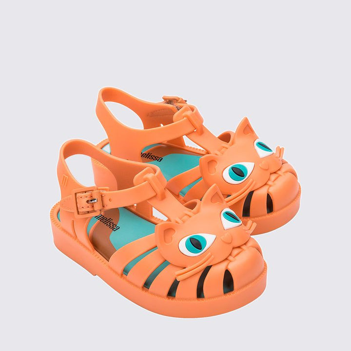 Sandália infantil Mini Melissa Possession Cat Baby nas cores laranja e azul, com aplicação de carinha de gatinho no cabedal. Confeccionada em Melflex, possui tiras vazadas, fecho com fivela e solado confortável. Um calçado divertido e estiloso para o dia a dia das crianças.

Palavra-chave principal: Mini Melissa Possession Cat Baby
Palavras-chave relacionadas: sandália infantil laranja azul, Melflex, sandália de gatinho, fecho com fivela, calçado baby confortável, estilo lúdico.