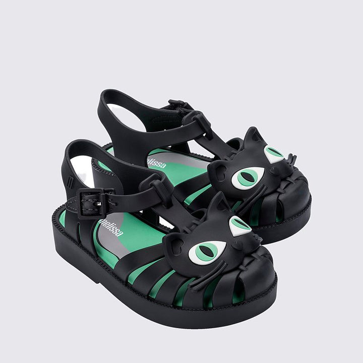 Sandália infantil Mini Melissa Possession Cat Baby nas cores preto e verde, com aplicação divertida de rosto de gatinho no cabedal. Confeccionada em Melflex, possui tiras vazadas, fecho lateral com fivela e solado confortável. Perfeita para looks lúdicos e estilosos no dia a dia.

Palavra-chave principal: Mini Melissa Possession Cat Baby
Palavras-chave relacionadas: sandália gatinho infantil, Melflex, preto e verde, fecho com fivela, calçado confortável, visual divertido, sandália baby.