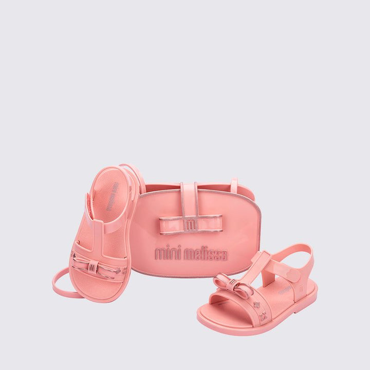 Sandália infantil Mini Melissa Imagine Baby nas cores rosa e lilás, com acabamento estampado fofo e delicado. Feita em material Melflex, macio, leve e confortável, possui fechamento ajustável que oferece segurança para os primeiros passos das pequenas. Acompanha uma linda bolsa de mão combinando, com capacidade de 1 litro, perfeita para carregar itens essenciais com charme e praticidade.