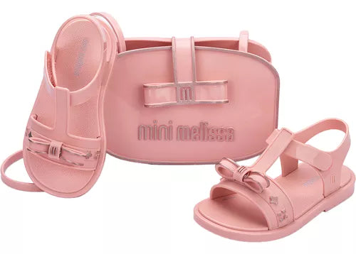Sandália infantil Mini Melissa Imagine Baby nas cores rosa com acabamento estampado fofo e delicado. Feita em material Melflex, macio, leve e confortável, possui fechamento ajustável que oferece segurança para os primeiros passos das pequenas. Acompanha uma linda bolsa de mão combinando, com capacidade de 5 litros, perfeita para carregar itens essenciais com charme e praticidade.