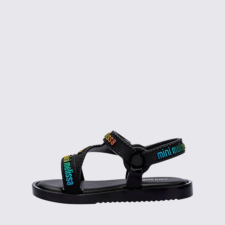 Sandália infantil Mini Melissa Stripes M.Lover Baby na cor preta, com tiras cruzadas, solado reto e fecho em velcro. Produzida em Melflex, é leve, confortável e segura, ideal para os primeiros passos com estilo e praticidade