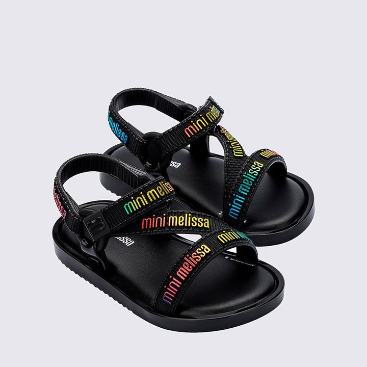 Sandália infantil Mini Melissa Stripes M.Lover Baby na cor preta, com tiras cruzadas, solado reto e fecho em velcro. Produzida em Melflex, é leve, confortável e segura, ideal para os primeiros passos com estilo e praticidade