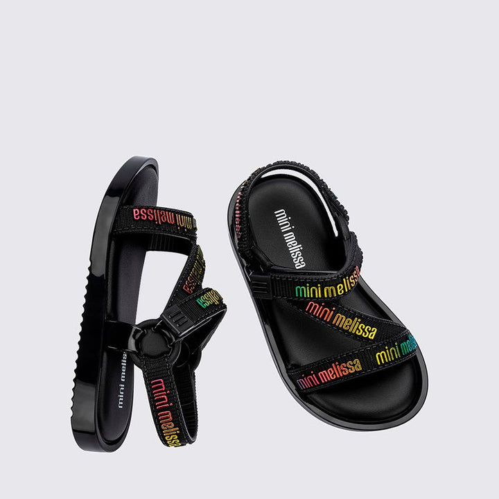 Sandália infantil Mini Melissa Stripes M.Lover Baby na cor preta, com tiras cruzadas, solado reto e fecho em velcro. Produzida em Melflex, é leve, confortável e segura, ideal para os primeiros passos com estilo e praticidade