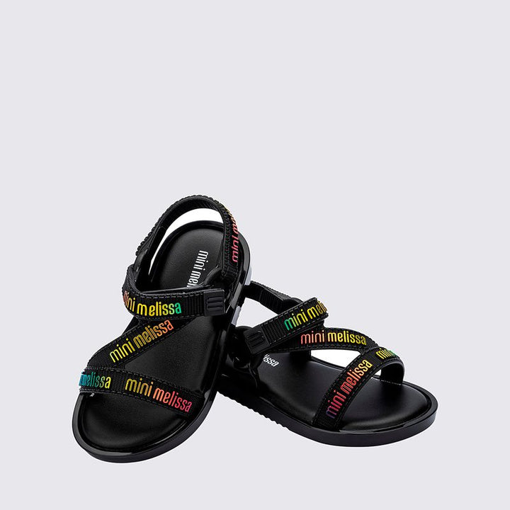 Sandália infantil Mini Melissa Stripes M.Lover Baby na cor preta, com tiras cruzadas, solado reto e fecho em velcro. Produzida em Melflex, é leve, confortável e segura, ideal para os primeiros passos com estilo e praticidade