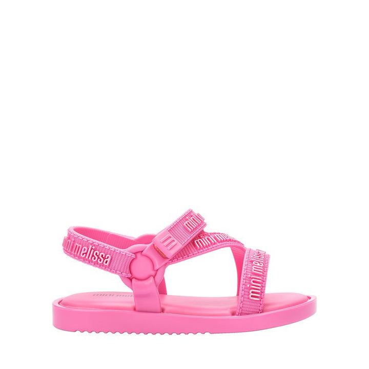 "Sandália infantil Mini Melissa Stripes M.Lover Baby na cor rosa, com tiras cruzadas, solado reto e fecho em velcro. Produzida em Melflex, é leve, macia e confortável, ideal para os primeiros passos com segurança, estilo e delicadeza