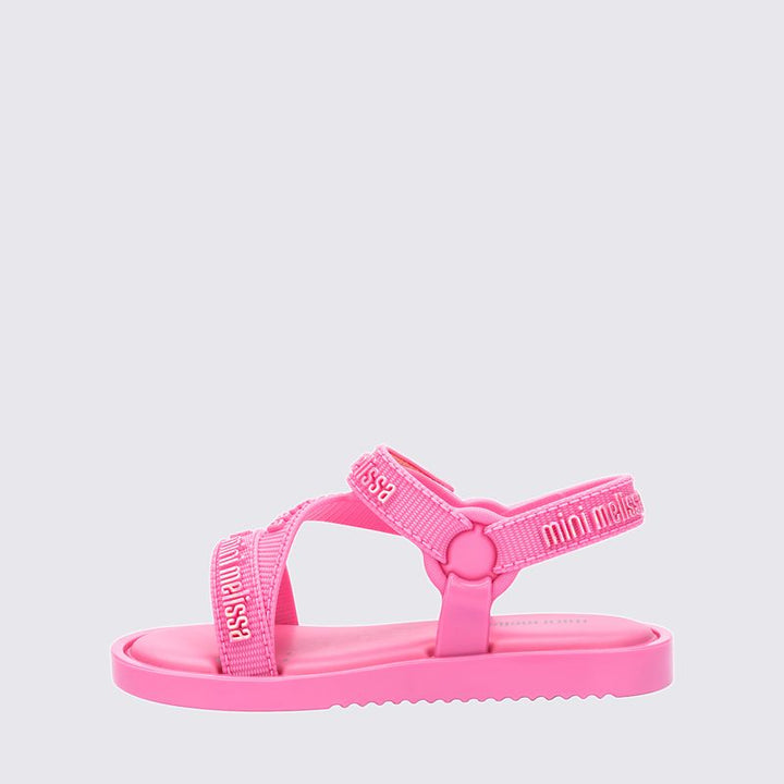 "Sandália infantil Mini Melissa Stripes M.Lover Baby na cor rosa, com tiras cruzadas, solado reto e fecho em velcro. Produzida em Melflex, é leve, macia e confortável, ideal para os primeiros passos com segurança, estilo e delicadeza