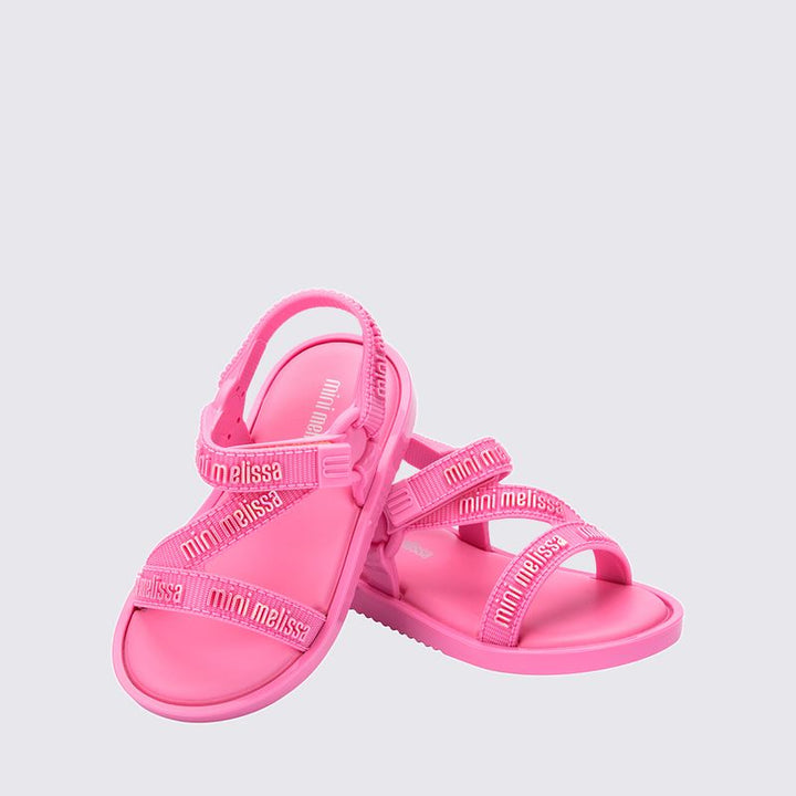 "Sandália infantil Mini Melissa Stripes M.Lover Baby na cor rosa, com tiras cruzadas, solado reto e fecho em velcro. Produzida em Melflex, é leve, macia e confortável, ideal para os primeiros passos com segurança, estilo e delicadeza