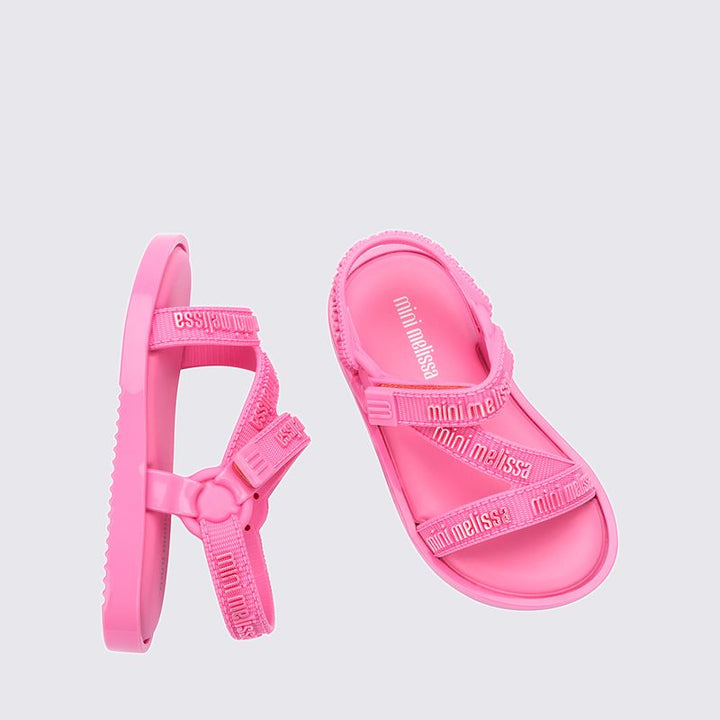 "Sandália infantil Mini Melissa Stripes M.Lover Baby na cor rosa, com tiras cruzadas, solado reto e fecho em velcro. Produzida em Melflex, é leve, macia e confortável, ideal para os primeiros passos com segurança, estilo e delicadeza