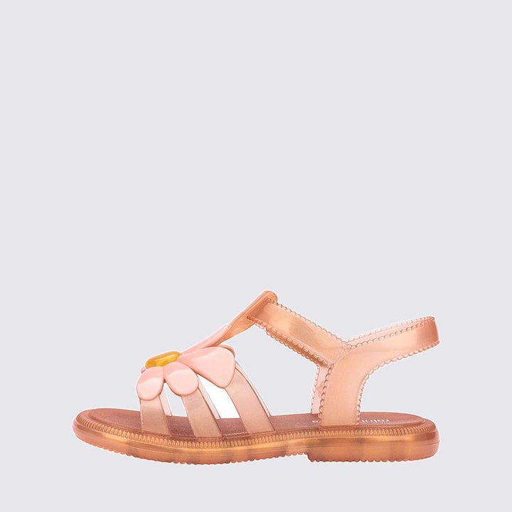 Sandália feminina Mini Melissa Kick Off com acabamento brilhante e efeito translúcido. Possui solado plataforma robusto com textura tratorada, tiras largas cruzadas na parte frontal e fechamento ajustável em velcro. O visual moderno e divertido combina facilmente com looks casuais e cheios de personalidade.