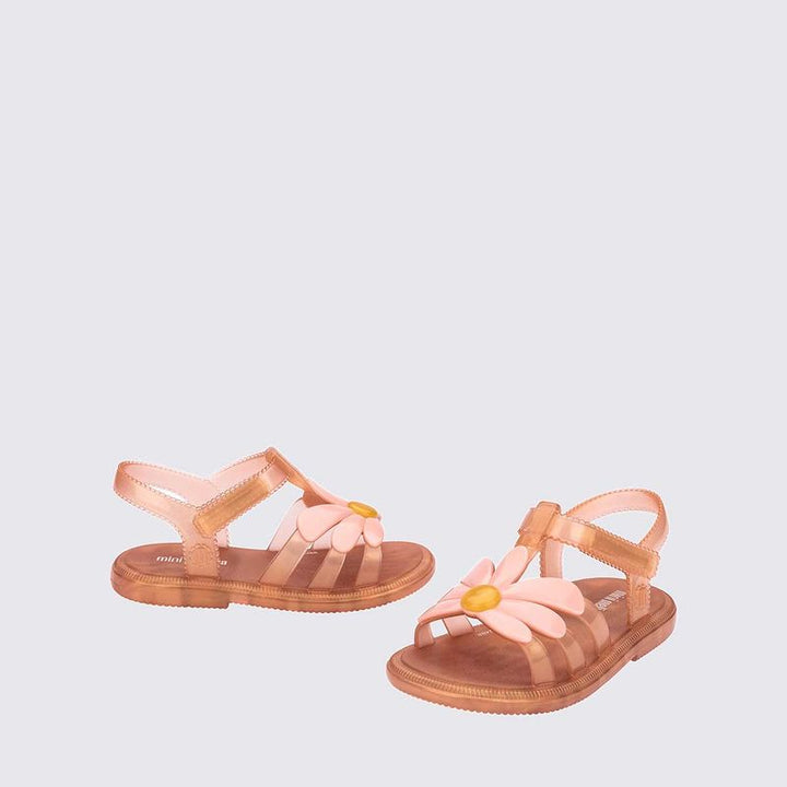 Sandália feminina Mini Melissa Kick Off com acabamento brilhante e efeito translúcido. Possui solado plataforma robusto com textura tratorada, tiras largas cruzadas na parte frontal e fechamento ajustável em velcro. O visual moderno e divertido combina facilmente com looks casuais e cheios de personalidade.