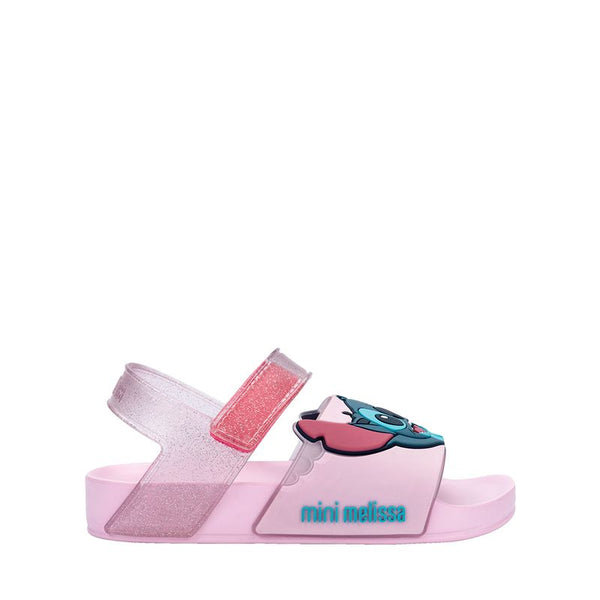 Sandália infantil Mini Melissa Flowing Sandal Stitch Baby nas cores rosa e azul, com aplique do personagem Stitch no cabedal. Produzida em Melflex, conta com tiras largas, solado confortável e fecho em velcro. Ideal para os pequenos que amam Disney com muito estilo e praticidade