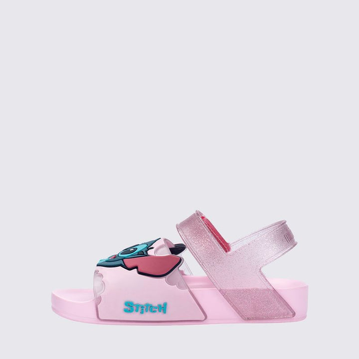 Sandália infantil Mini Melissa Flowing Sandal Stitch Baby nas cores rosa e azul, com aplique do personagem Stitch no cabedal. Produzida em Melflex, conta com tiras largas, solado confortável e fecho em velcro. Ideal para os pequenos que amam Disney com muito estilo e praticidade