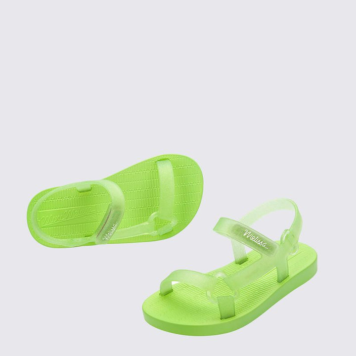 Sandália infantil Mini Melissa Sun Downtown Baby na cor verde com glitter, acabamento brilhante e design unissex. Produzida em Melflex, é leve, confortável e possui fechamento em velcro para mais segurança. Ideal para dias ensolarados e combinações