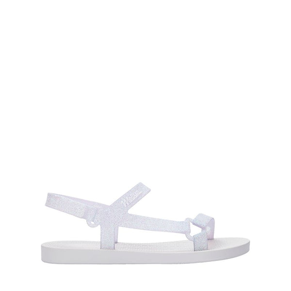 Mini Melissa Sun Downtown II 36099 na versão Branco/Vidro com acabamento glitterizado é perfeita para as pequenas que amam estar estilosas até nos momentos mais simples Leve (só 290g!) e feita em Melflex, essa sandália é flexível, durável e superconfortável. O design moderno combinado com o brilho sutil do glitter