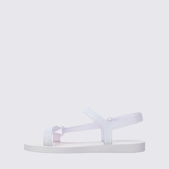 Mini Melissa Sun Downtown II 36099 na versão Branco/Vidro com acabamento glitterizado é perfeita para as pequenas que amam estar estilosas até nos momentos mais simples Leve (só 290g!) e feita em Melflex, essa sandália é flexível, durável e superconfortável. O design moderno combinado com o brilho sutil do glitter