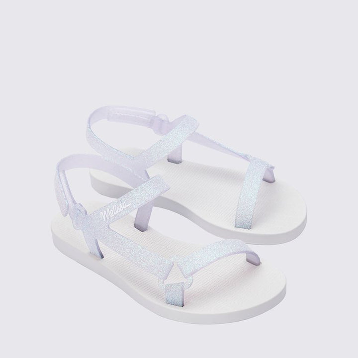 Mini Melissa Sun Downtown II 36099 na versão Branco/Vidro com acabamento glitterizado é perfeita para as pequenas que amam estar estilosas até nos momentos mais simples Leve (só 290g!) e feita em Melflex, essa sandália é flexível, durável e superconfortável. O design moderno combinado com o brilho sutil do glitter