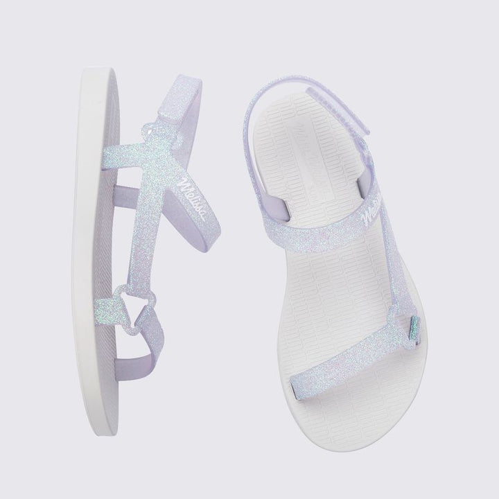 Mini Melissa Sun Downtown II 36099 na versão Branco/Vidro com acabamento glitterizado é perfeita para as pequenas que amam estar estilosas até nos momentos mais simples Leve (só 290g!) e feita em Melflex, essa sandália é flexível, durável e superconfortável. O design moderno combinado com o brilho sutil do glitter