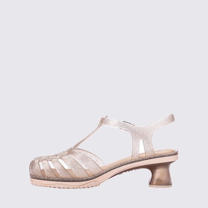 Sandália infantil Mini Melissa Vixen na cor bege com acabamento glitterizado. Modelo com tiras cruzadas e solado reto, feita em Melflex. Leve, confortável e estilosa, ideal para o dia a dia das crianças com um toque de brilho e charme