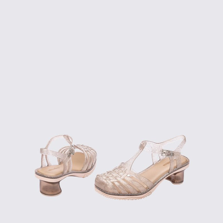 Sandália infantil Mini Melissa Vixen na cor bege com acabamento glitterizado. Modelo com tiras cruzadas e solado reto, feita em Melflex. Leve, confortável e estilosa, ideal para o dia a dia das crianças com um toque de brilho e charme