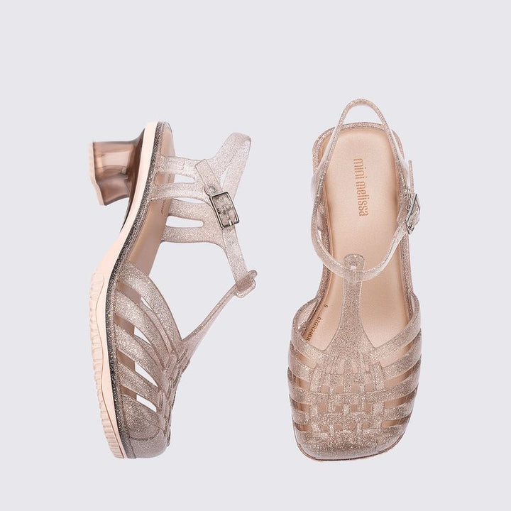 Sandália infantil Mini Melissa Vixen na cor bege com acabamento glitterizado. Modelo com tiras cruzadas e solado reto, feita em Melflex. Leve, confortável e estilosa, ideal para o dia a dia das crianças com um toque de brilho e charme