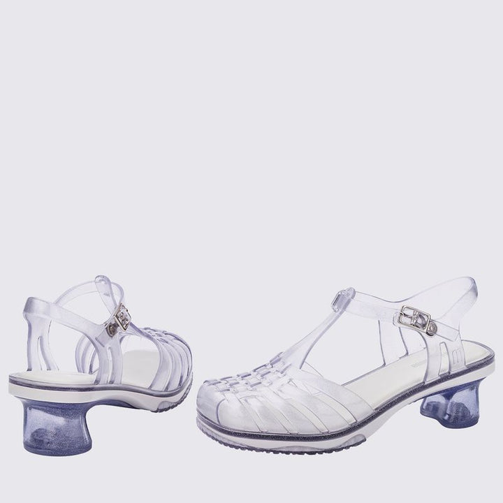 Sandália infantil Mini Melissa Vixen na cor branco com acabamento vidro e glitter. Modelo estiloso com tiras cruzadas e solado reto. Produzida em Melflex, leve, confortável e perfeita para compor looks modernos e divertidos para as crianças