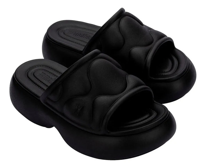 Melissa Free Puff Platform Slide leve com efeito puffer ultra confortável, cabedal acolchoado com efeito puffer + textura quilted cria um look moderno. Confira!
