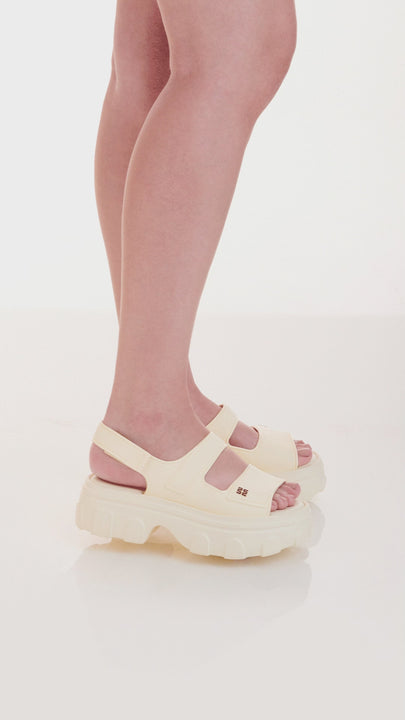 Sandália adulta Melissa Ella diversas cores, com tiras largas, fecho ajustável no tornozelo e acabamento brilhante. Produzida em Melflex, é leve, confortável e ideal para compor looks casuais e românticos com um toque de estilo moderno